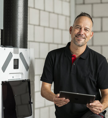 Service-Technician with Tablet smiling before at Comfo-Systems-Unit