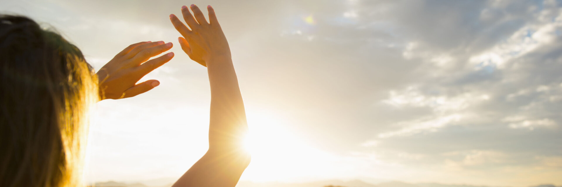 Hispanic woman shielding eyes from sun on remote road