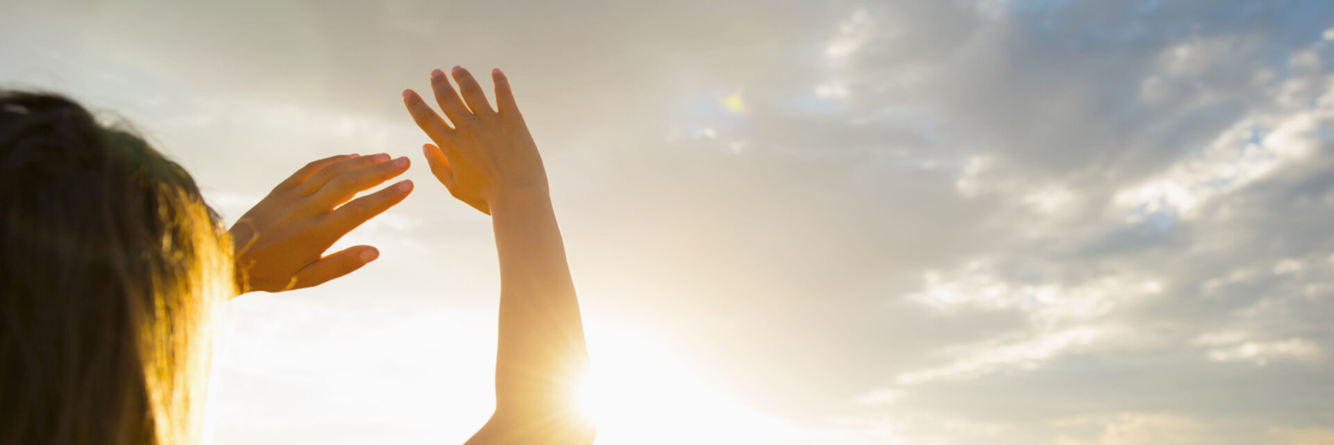 Hispanic woman shielding eyes from sun on remote road